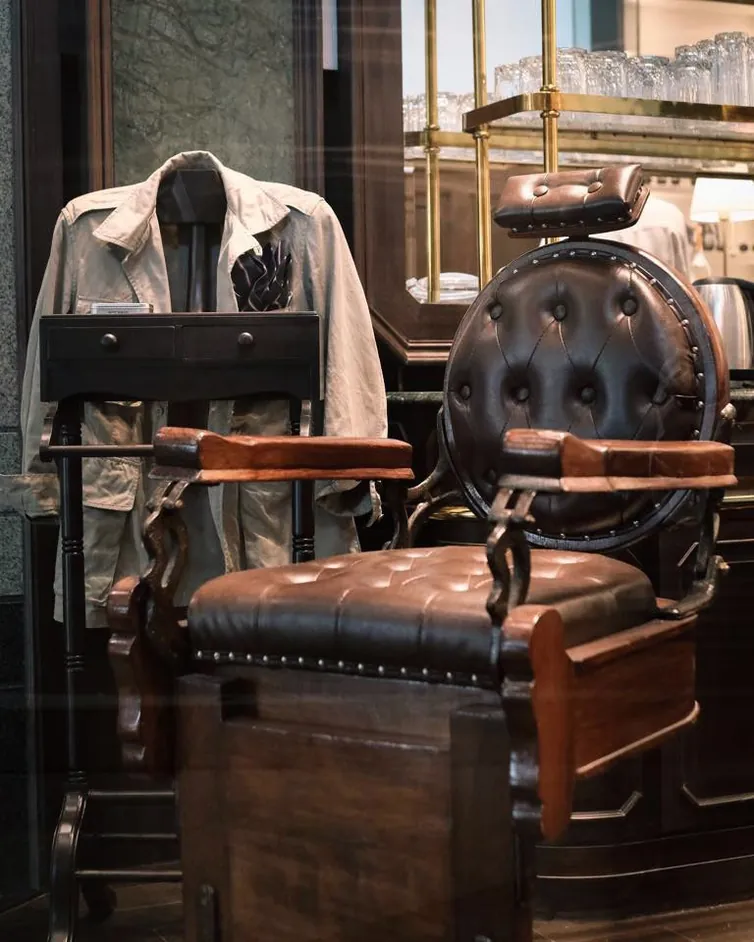 A leather barber&rsquo;s chair and hanging jackets inside Black Amber Barber Shop and Tattoo