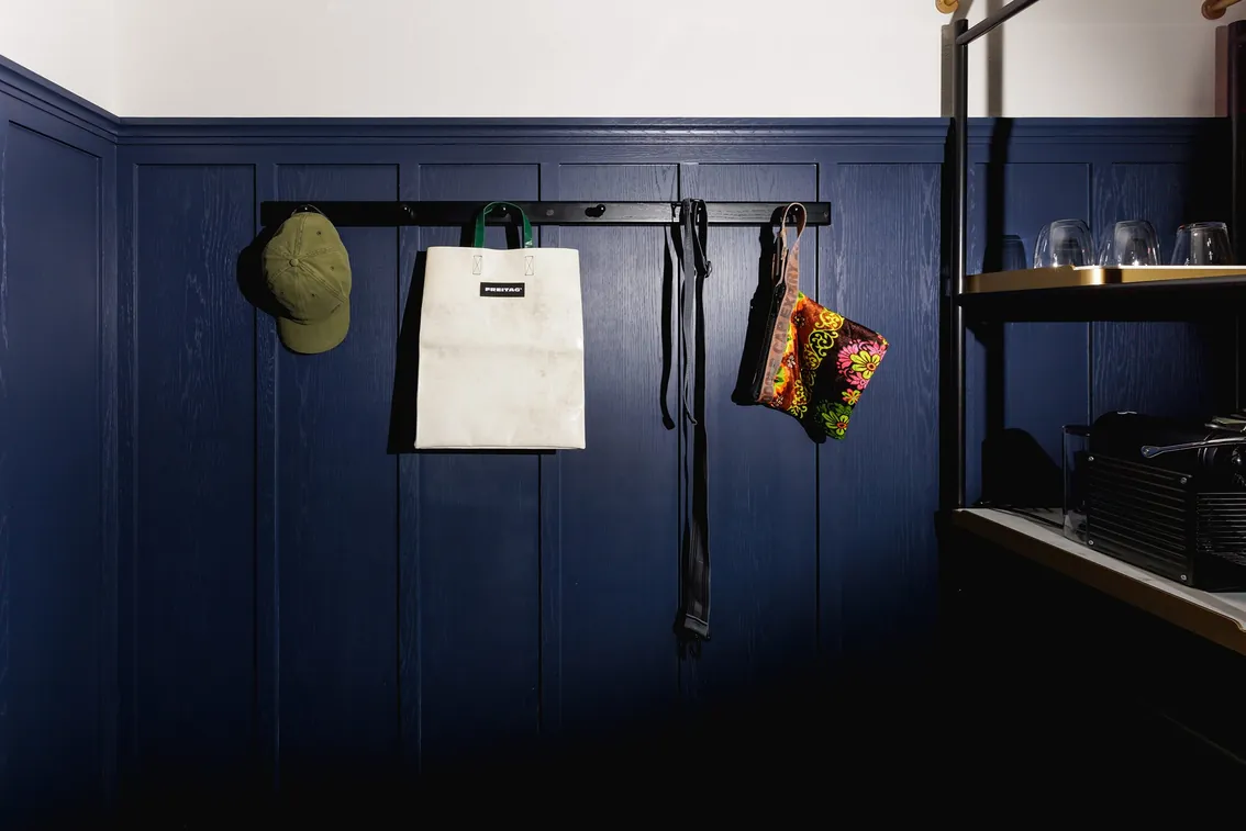 Navy panelled pantry with glassware and a coffee machine in the Two-Bedroom Suite
