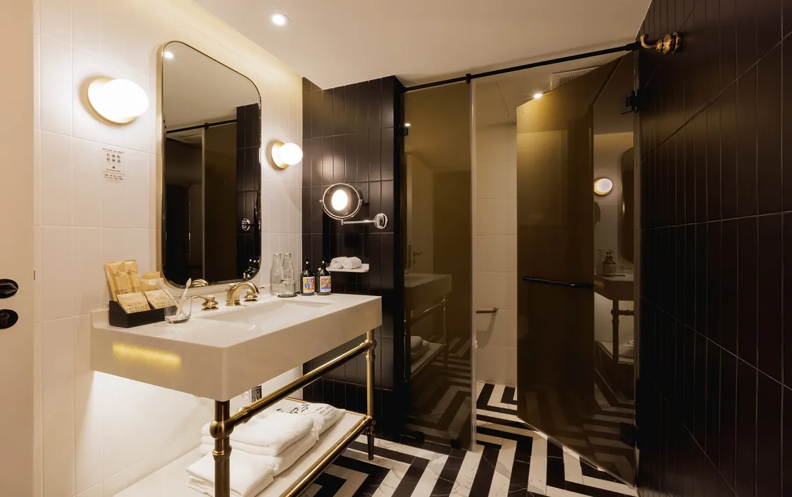 Bathroom vanity with round mirrors in the Junior Suite half of the Two-Bedroom Suite at Public House Bangkok