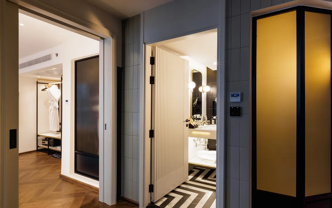 Hallway of the Two-Bedroom Suite looking through to a bathroom laid in chevron marble
