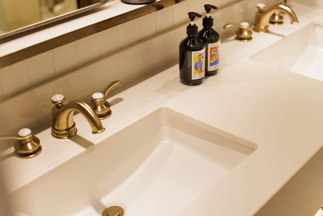 Brass tapware on a twin basin, with bath amenities