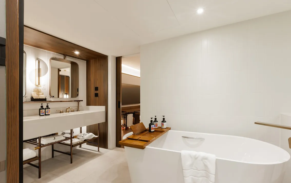 Bathroom with a twin washstand and a freestanding tub