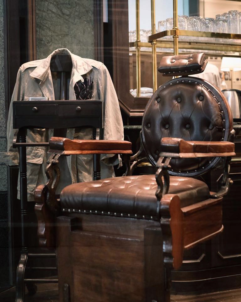 A leather barber&rsquo;s chair and hanging jackets inside Black Amber Barber Shop and Tattoo