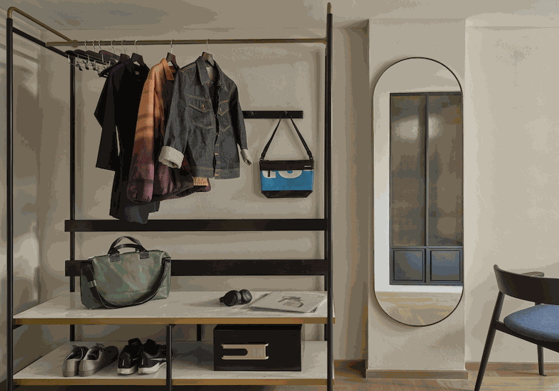 Open wardrobe rail with an oval mirror in a room at Public House Bangkok