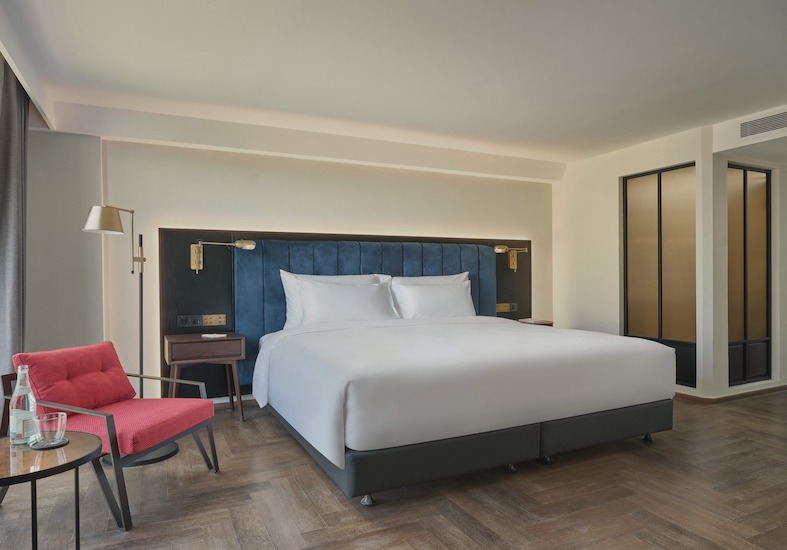 Day Dreamer Room with a king bed, deep navy headboard and a red armchair