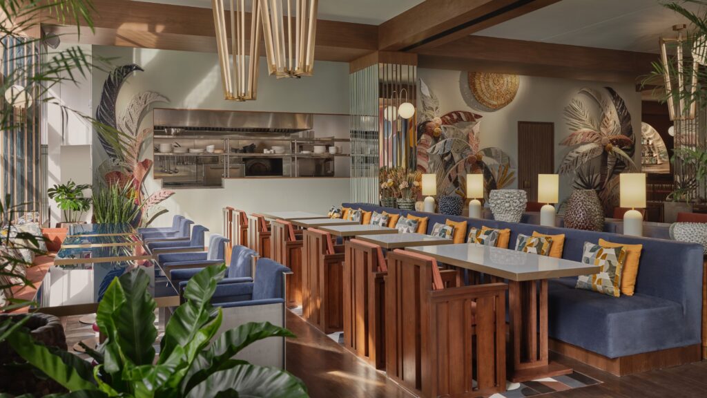 A dining room on Sukhumvit 31, timber banquettes and planting under brass pendants