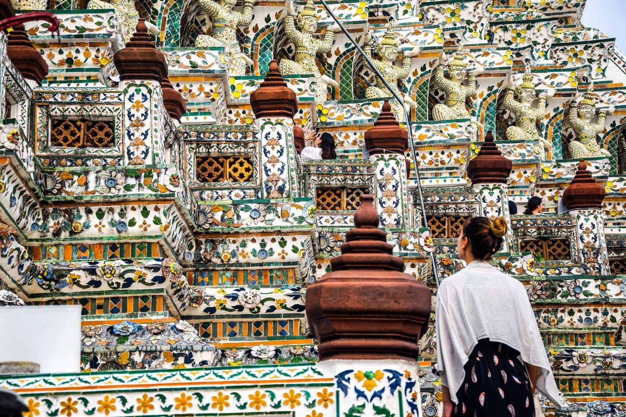 A visitor on the porcelain-tiled steps of Wat Arun