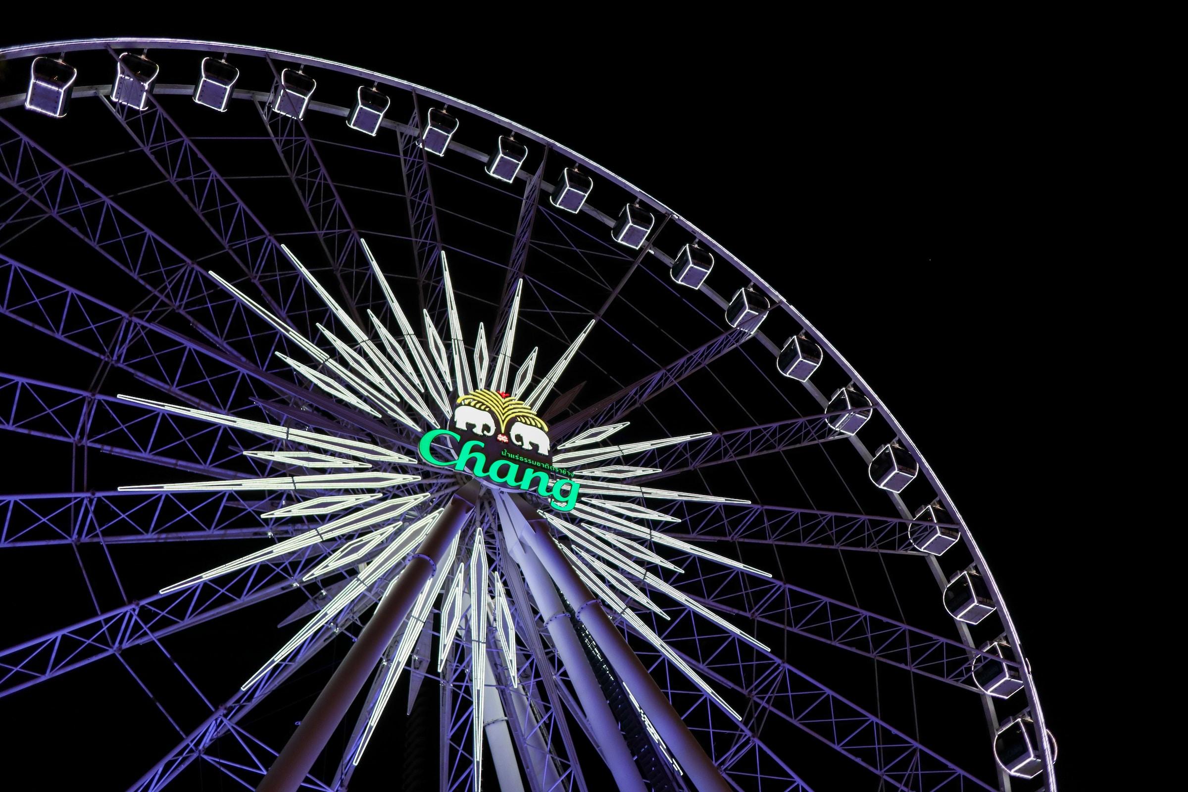 A lit ferris wheel against the night sky in Bangkok