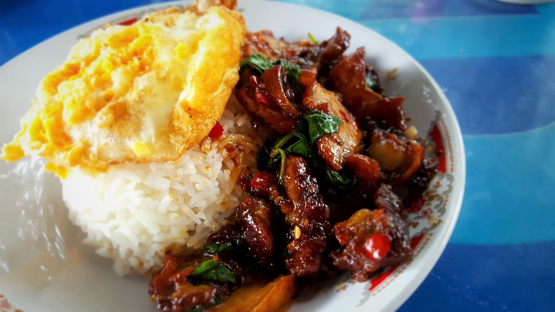 Stir-fried pork and basil with a fried egg over rice