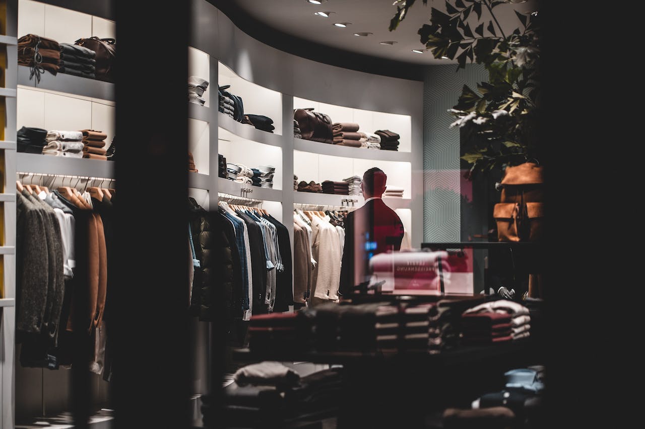 Shirts on rails in a curved, dimly lit Bangkok clothing boutique