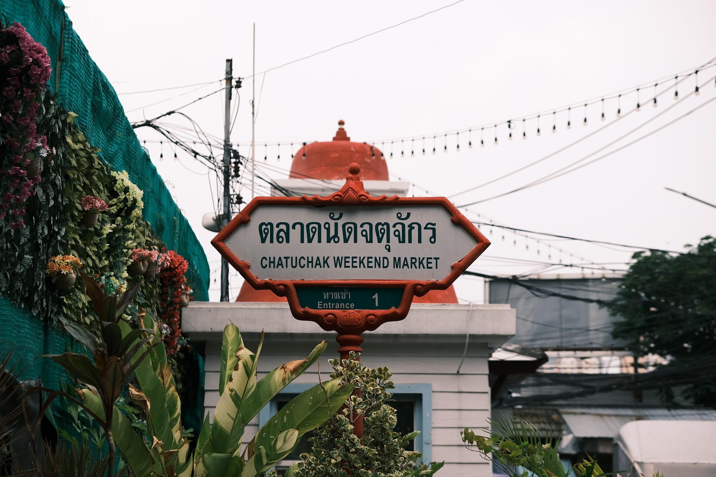 The Chatuchak Weekend Market gateway sign above a Bangkok street