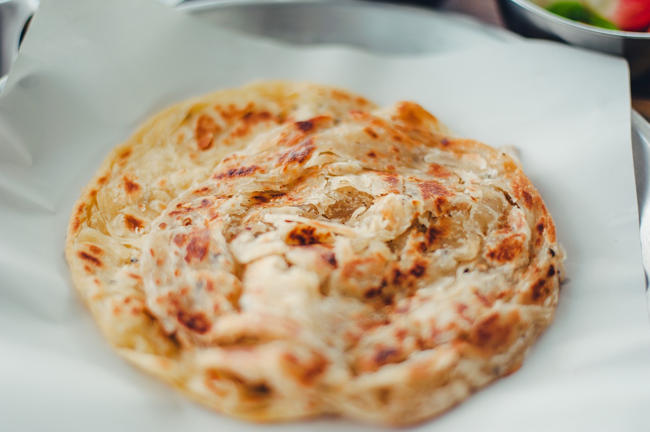 A freshly griddled roti on a white plate