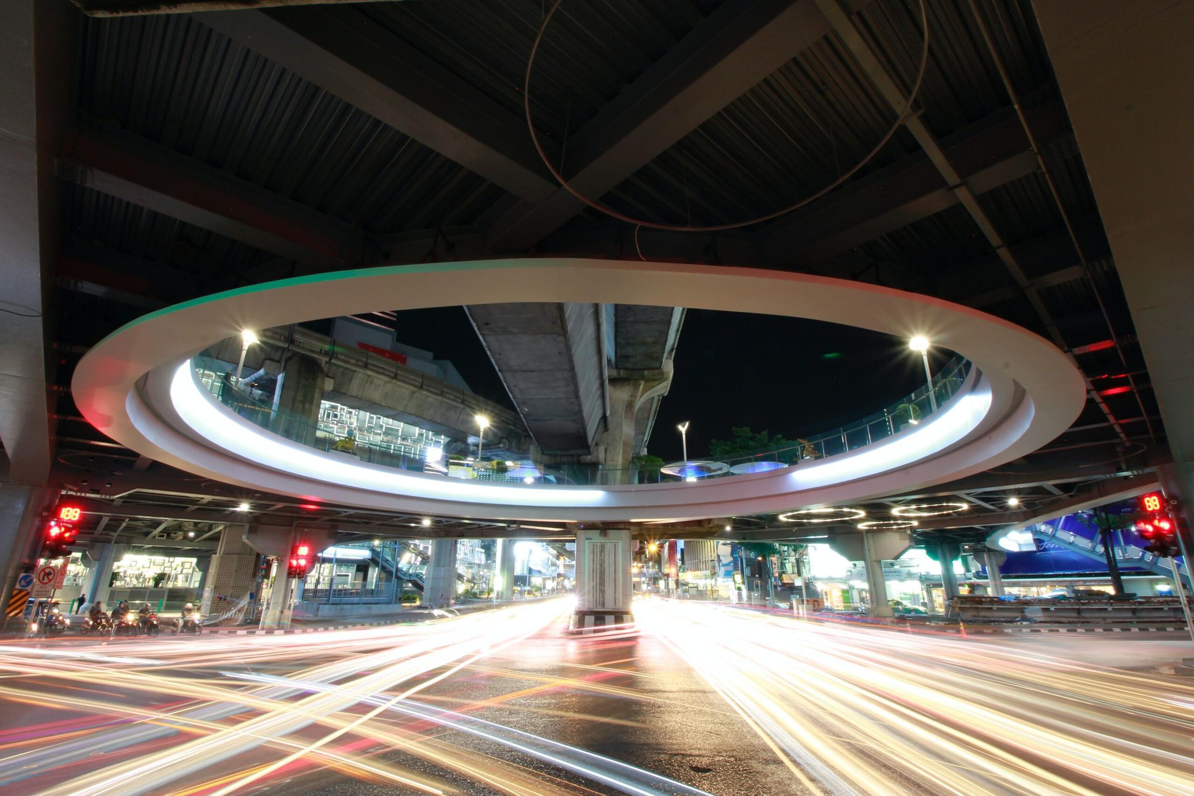 Traffic light trails under an elevated expressway ring in Bangkok at night
