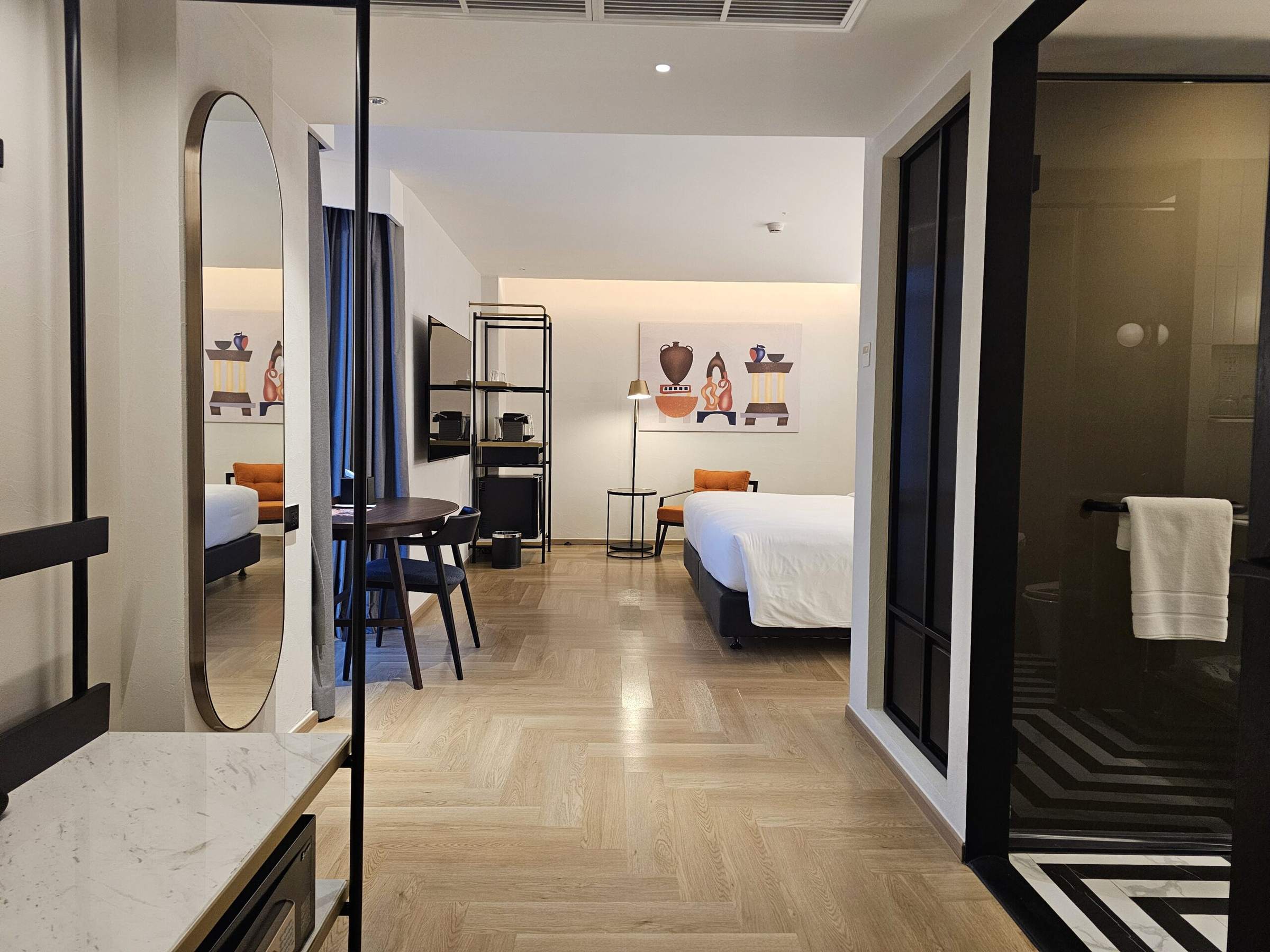 Open wardrobe rail and full-length mirror looking through to the bed in a Downtown Room