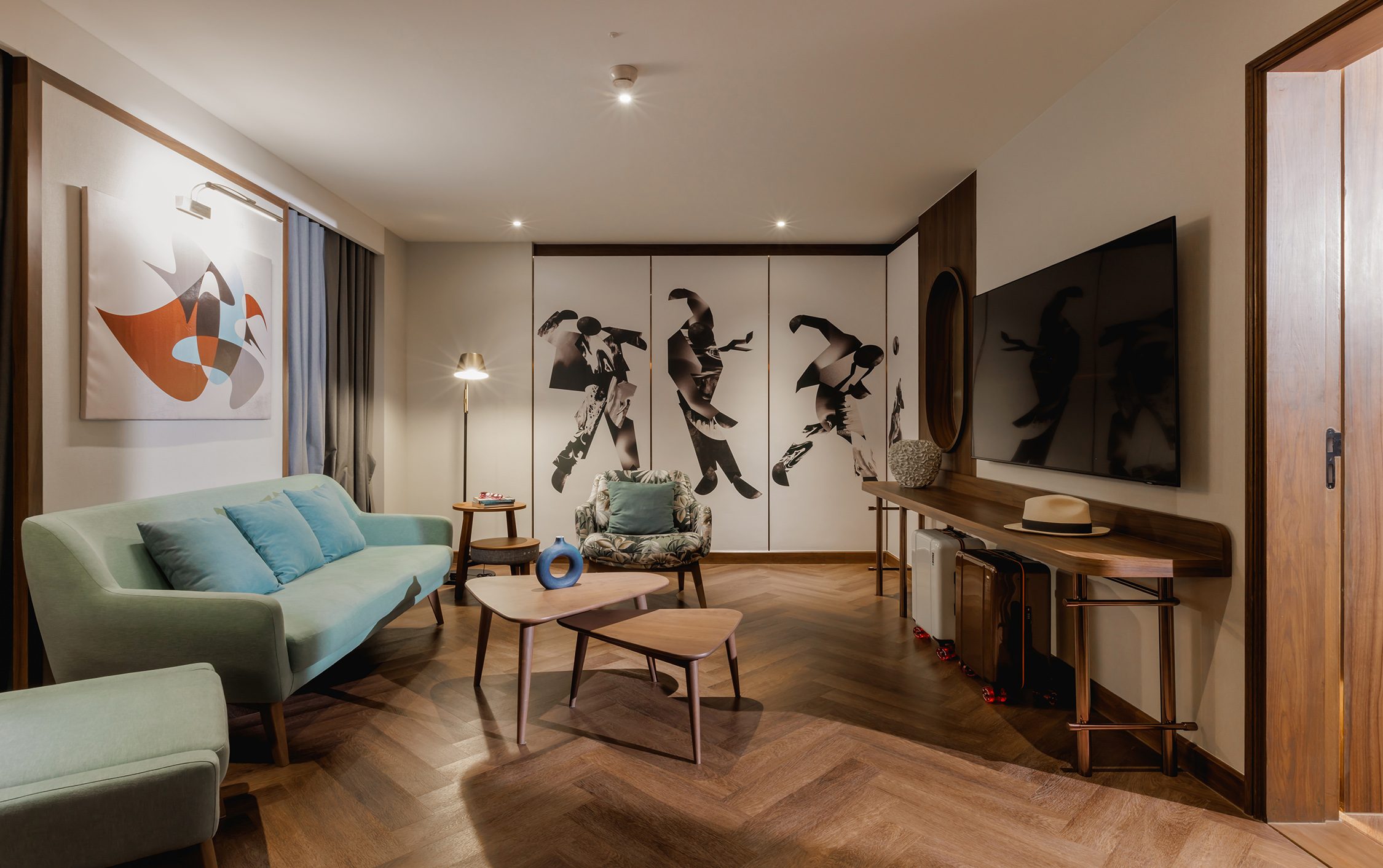 Living room with a green sofa, framed artwork and a console table