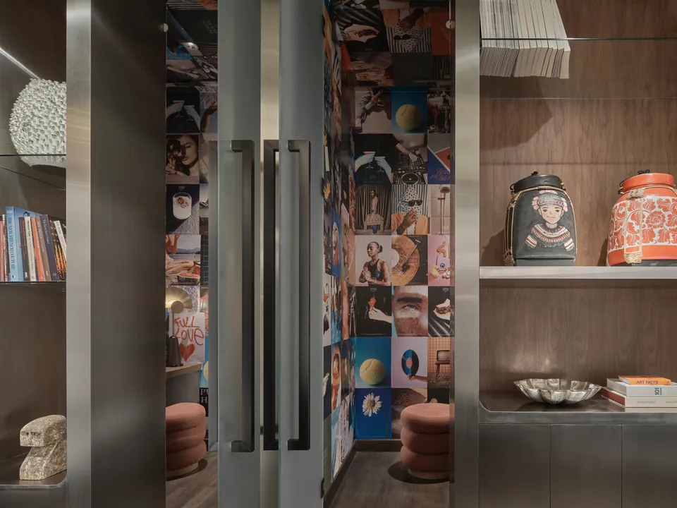 Objects and prints in the lit lobby vitrine at Public House Bangkok