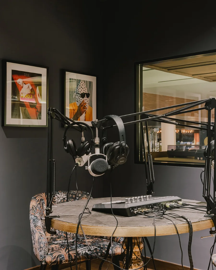 The recording set-up in The Podcast Lounge at Public House Bangkok: microphone booms, headphones and a mixer on a round stone table