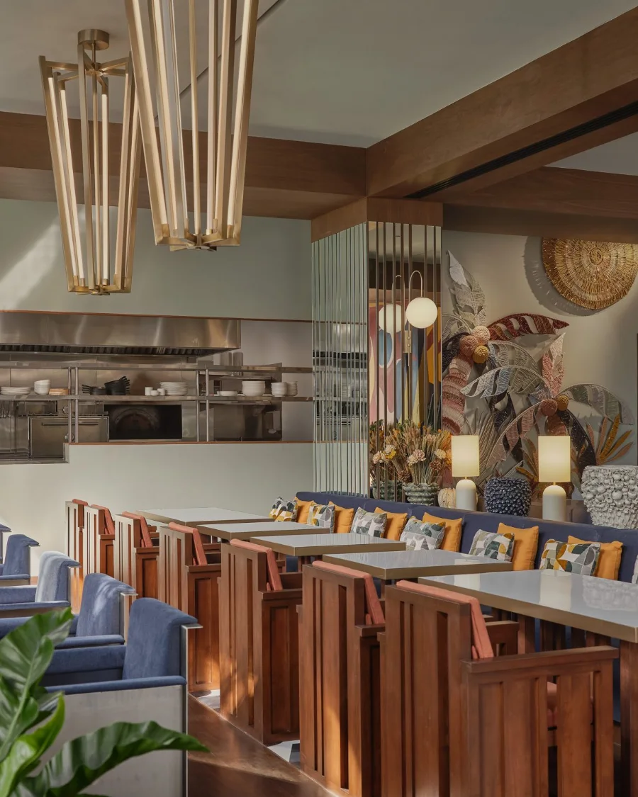 A private dining room at Public House Bangkok, with brass pendant lights over banquette seating and an open kitchen counter