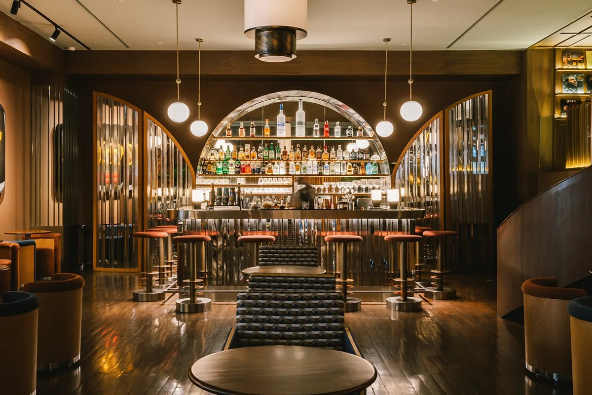 OPEN BAR at Public House Bangkok: an arched back bar lined with bottles, stools along the counter and low seating in the foreground