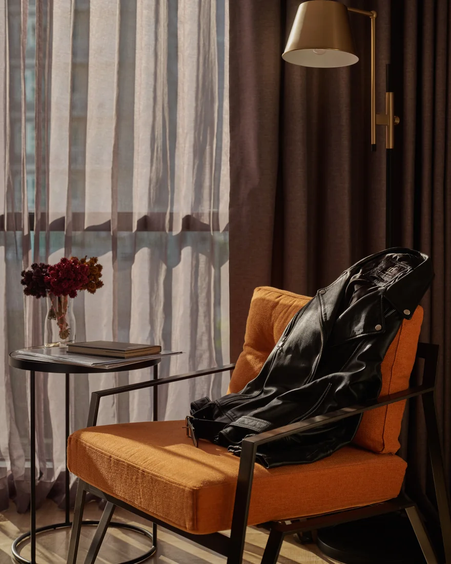 A velvet armchair and dried flowers in a guest room at Public House Bangkok