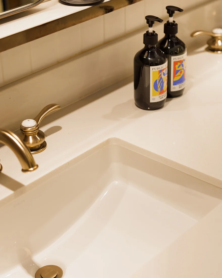 Brass taps and a stone basin in a suite bathroom at Public House Bangkok