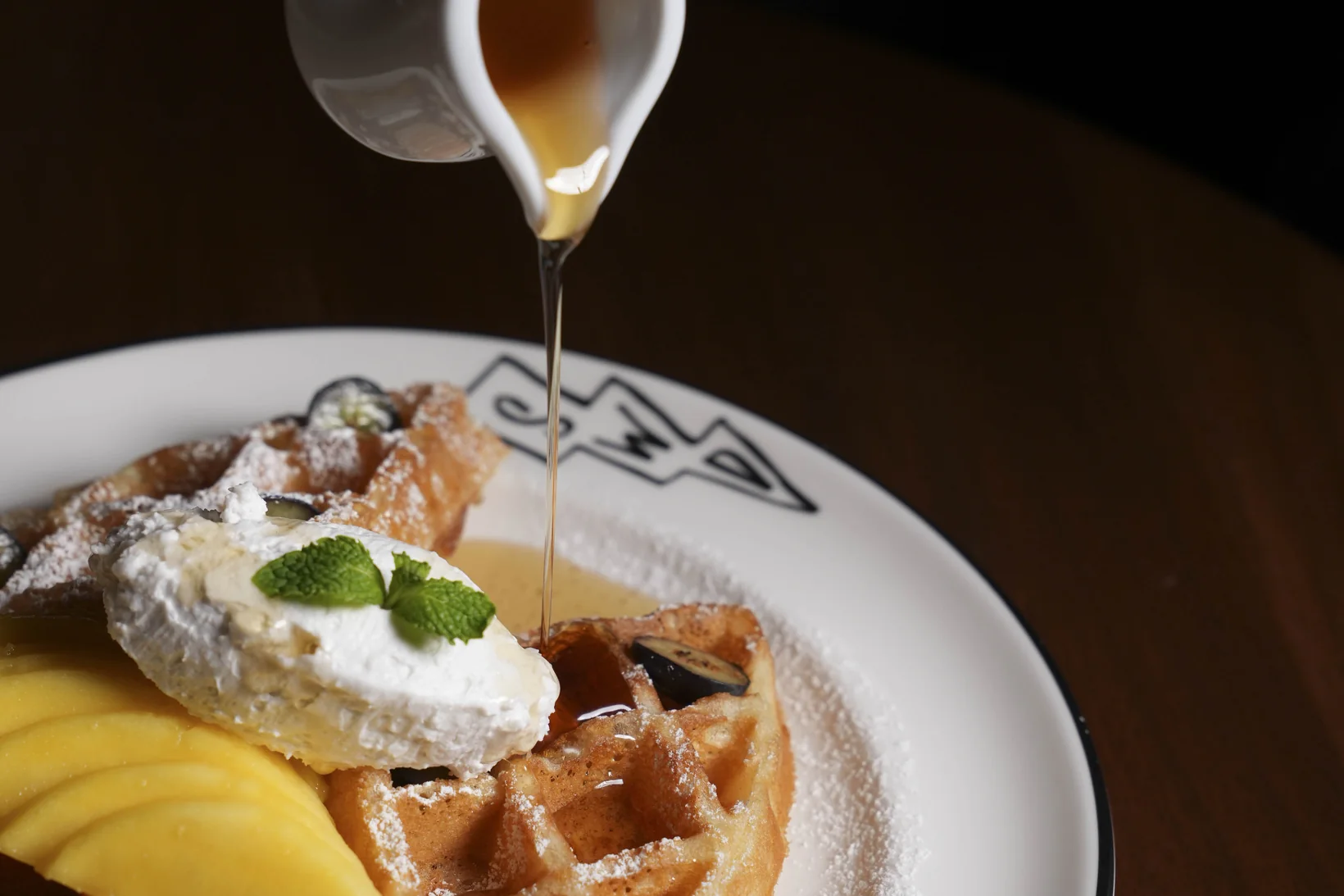 A waffle with mango, cream and maple syrup, served at Public House Bangkok