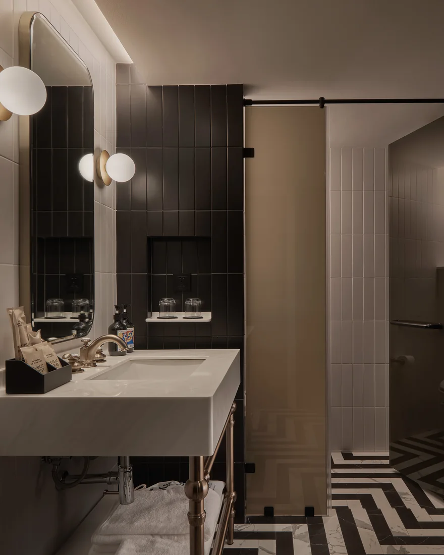 A guest bathroom at Public House Bangkok, with a wall-hung basin