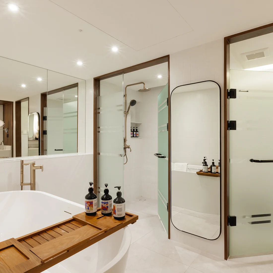 A freestanding bath and walk-in shower in a suite at Public House Bangkok