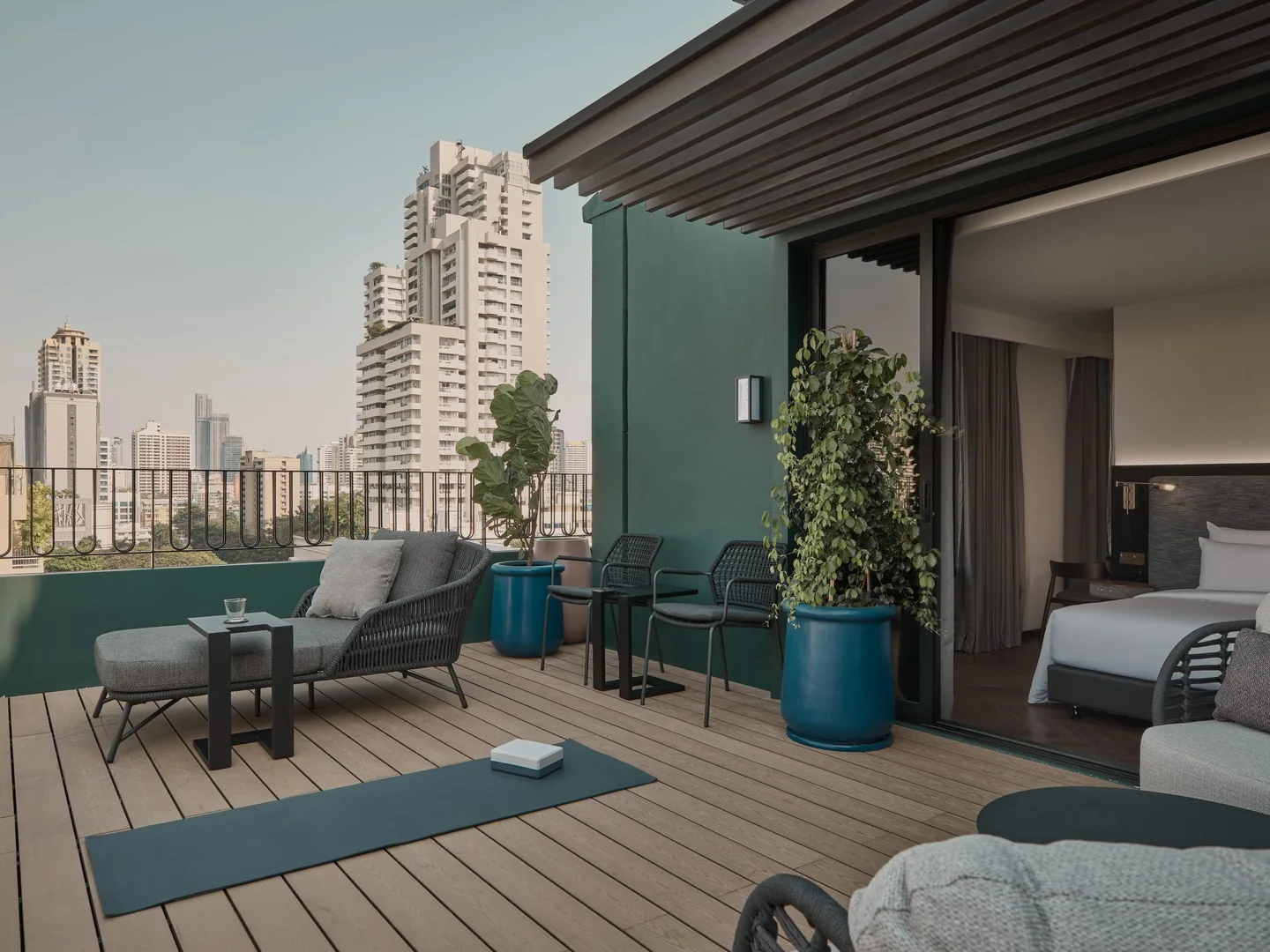 The private terrace of the Sky Terrace Room at Public House Bangkok, with outdoor seating above the Sukhumvit skyline